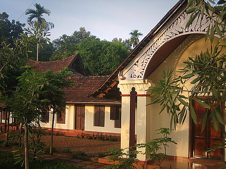 The carved wooden gable over the cottage entrance, lit by late afternoon sun